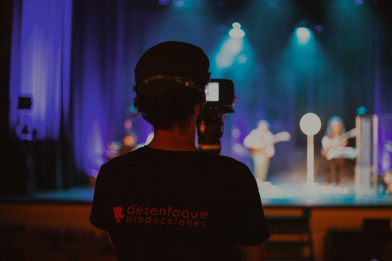 persona con c&aacute;mara de la empresa Desenfoque Producciones graba una actuaci&oacute;n musical